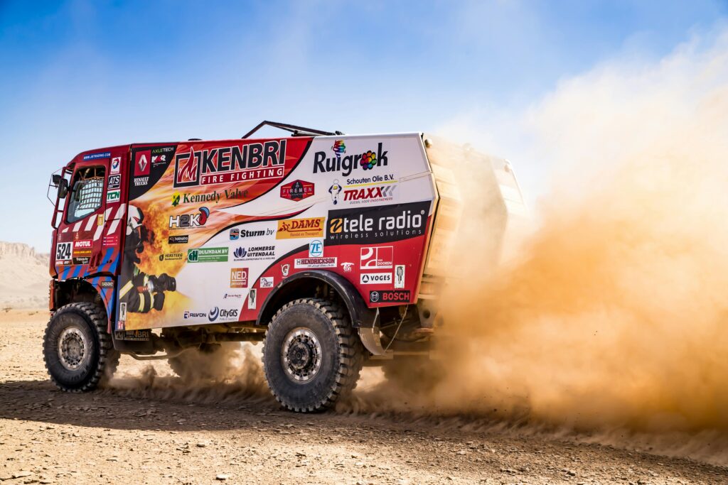 Powerful rally truck kicks up dust in a thrilling desert race. Off-road adventure captured in action.