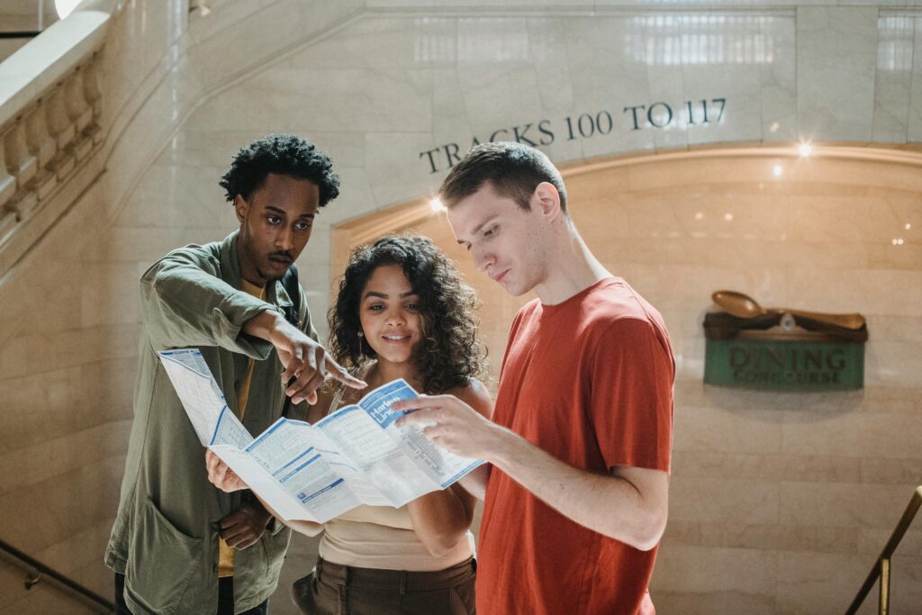 Young adults examining a map indoors at Grand Central Terminal.