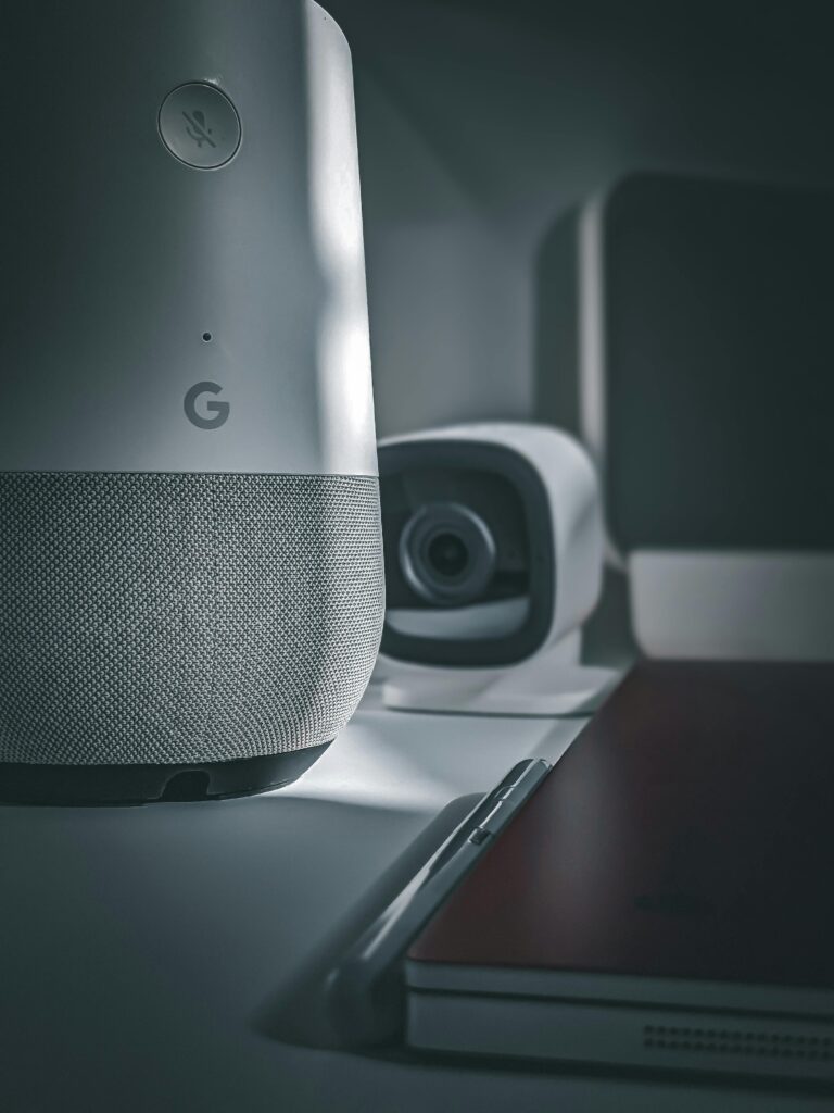 Close-up of smart home devices, showcasing a modern speaker and camera setup in a minimalist style.