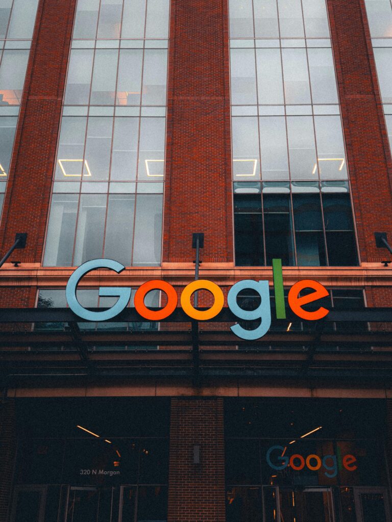 Colorful Google logo on modern building exterior in urban environment.