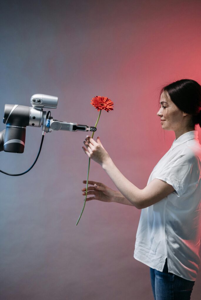 A woman interacts with a robotic arm holding a flower, symbolizing human-technology harmony.