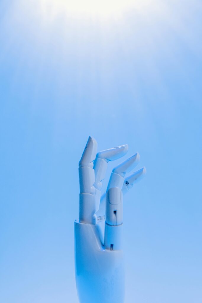 A robotic hand reaching upward against a blue sky, symbolizing technology's future.